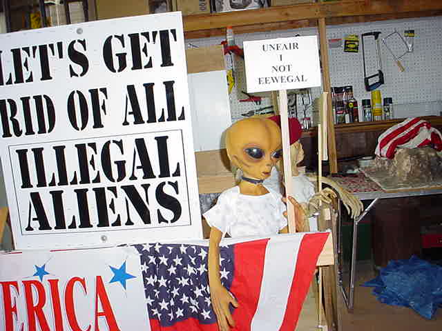 http://www.tellmewhereonearth.com/Web%20Pages/Aliens/Alien%20photos/aliens%20alien%20with%20illegal%20aliens%20sign.jpg